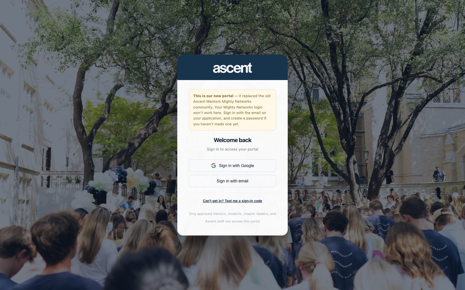 Ascent Basecamp sign-in screen: a centred white card with a navy header reading &lsquo;ascent&rsquo;, a Welcome back heading, Sign in with Google and Sign in with email buttons, and a text-message fallback link, over a photograph of a campus gathering